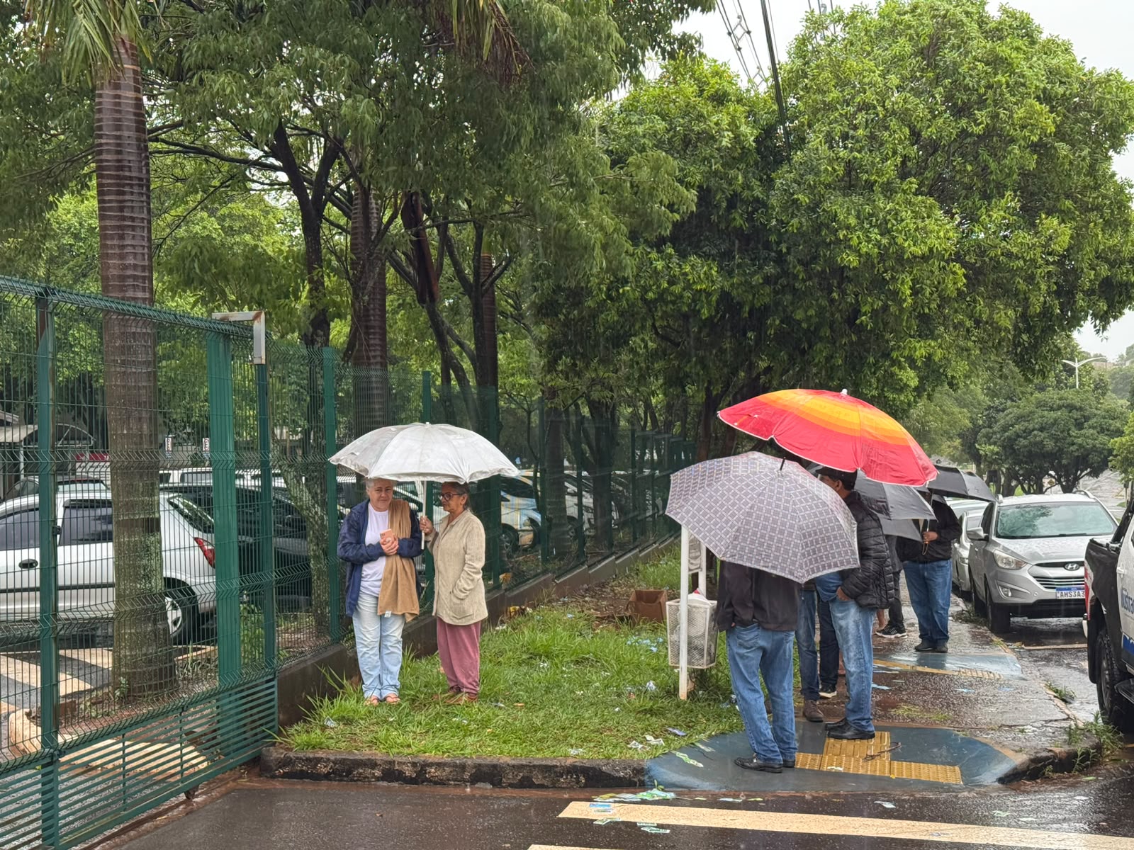 Eleitores aguardam embaixo de chuvas portões abrirem para votar na UEM em Umuarama